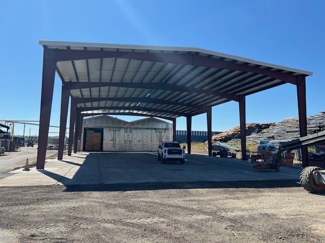 A large metal structure with cars parked in it.